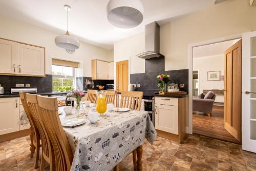 a kitchen and dining room with a table and chairs at Orroland Holiday Cottages in Dundrennan