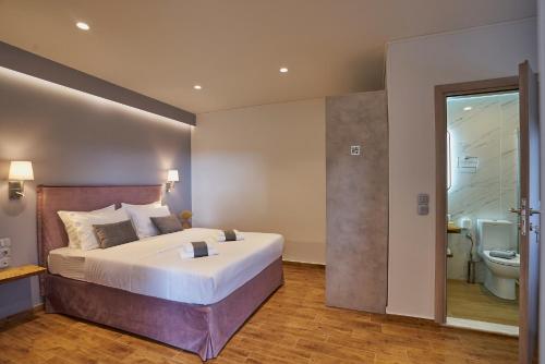 1 dormitorio con 1 cama grande y baño en Apartments Gonies - Artemis, en Goníai
