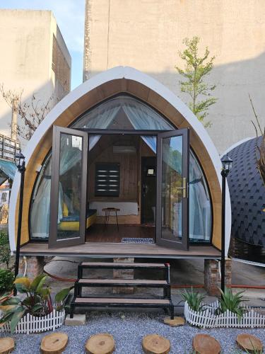 a small dome house with a bench in a yard at Mio Hotel in Hải Dương