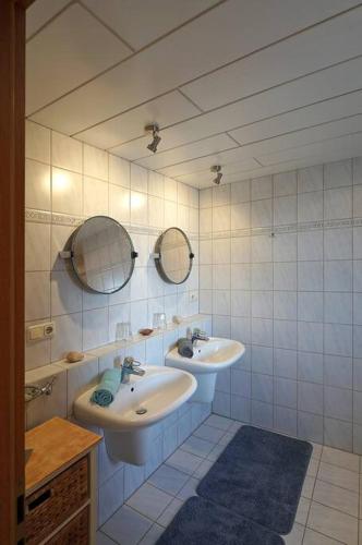a bathroom with two sinks and two mirrors at Habos Corner in Tiefenbach