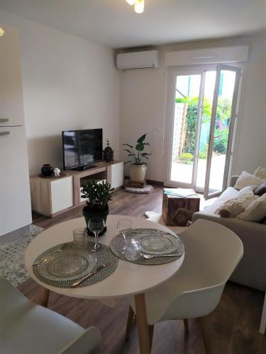 un salon avec une table et un canapé dans l'établissement Studio jardin et plage à 13 min à pied, à Fréjus