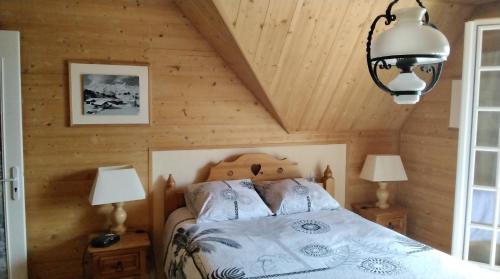 une chambre avec un lit dans une pièce en bois dans l'établissement La Maison Bleue Normande, à Étretat