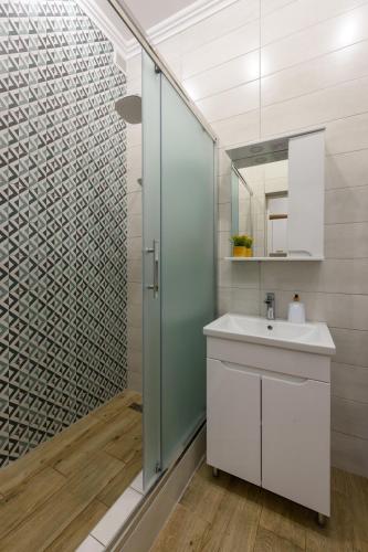 a bathroom with a sink and a glass shower at Апартаменти на Кобилянській by Willox in Chernivtsi