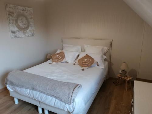 a bedroom with a white bed with two pillows on it at Le manège Gite Etretat in Sainte-Marie-au-Bosc