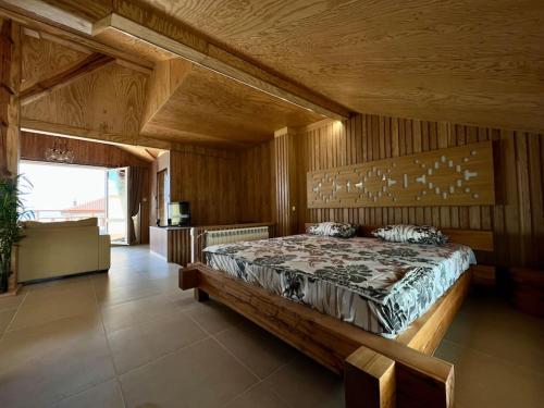 a bedroom with a large bed with a wooden wall at Seagull Studio Byala in Byala