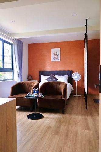 a bedroom with a bed and a couch and a table at De La Sol Villa Dalat in Da Lat