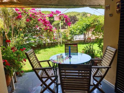 a table and chairs on a patio with flowers at Apartamento a pie de playa con jardin privado in Rota