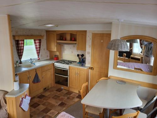 - une petite cuisine avec une table dans une caravane dans l'établissement Mobil Home à la ferme, à Le Neufbourg