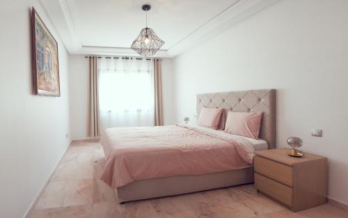 a bedroom with a large bed with pink pillows at Appartement au coeur du parc de Mohammedia Haut Standing in Mohammedia