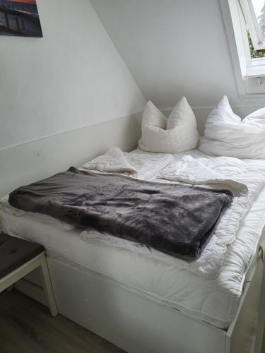 a white bed with a blanket on top of it at FeWo Baron in Kleinwessek