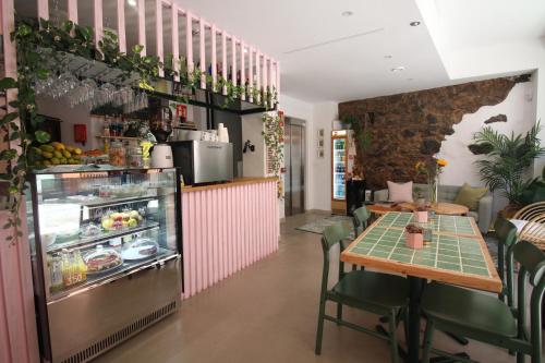 un restaurant avec une table et un réfrigérateur. dans l'établissement Banana Garden La Palma, à Santa Cruz de la Palma