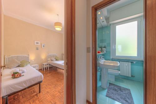 Cette chambre comprend un lit et une salle de bains pourvue d'un lavabo. dans l'établissement Attico con Terrazza e Piscina, à Camogli