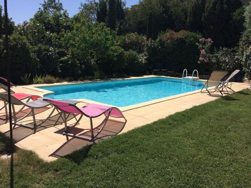 um grupo de cadeiras e uma piscina em maison de vacances avec piscine à Saint Remy de Provence em Saint-Rémy-de-Provence