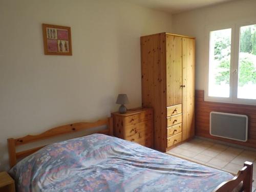 um quarto com uma cama, uma cómoda e uma janela em maison de vacances avec piscine à Saint Remy de Provence em Saint-Rémy-de-Provence
