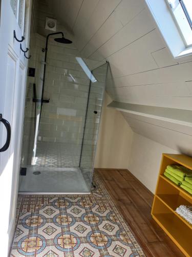 a bathroom with a glass shower in a attic at Lodge De Zandbalk in Sebaldeburen