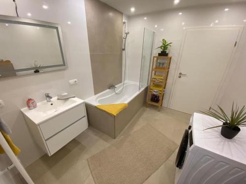 ein Bad mit einer Badewanne, einem Waschbecken und einer Dusche in der Unterkunft Ferienwohnung Eifel Stadtkyll in Stadtkyll