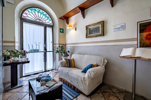 a living room with a couch and a window at Hotel Minerva in Pisa