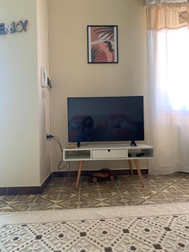 einen Flachbild-TV auf einem Tisch im Wohnzimmer in der Unterkunft Casa Vacanze La Brii in Iglesias