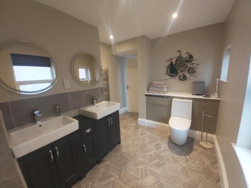 a bathroom with a sink and a toilet and a mirror at Bay House in Totland