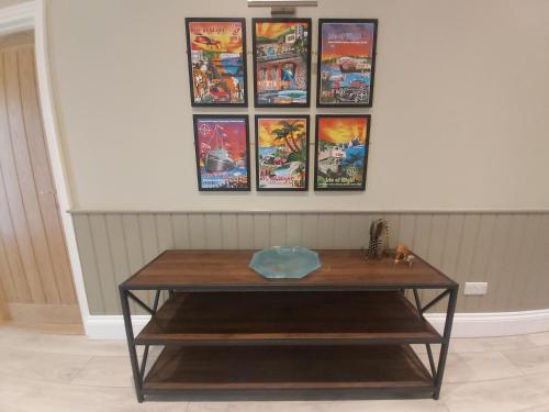 a coffee table with four pictures on the wall at Bay House in Totland