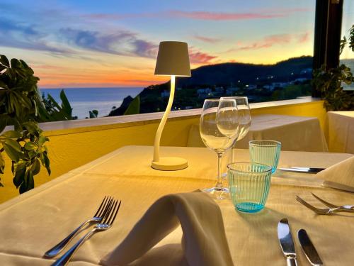 伊斯基亞的住宿－Borgo Romantica - Resort & Spa，一张桌子,上面放着两杯酒和一盏灯