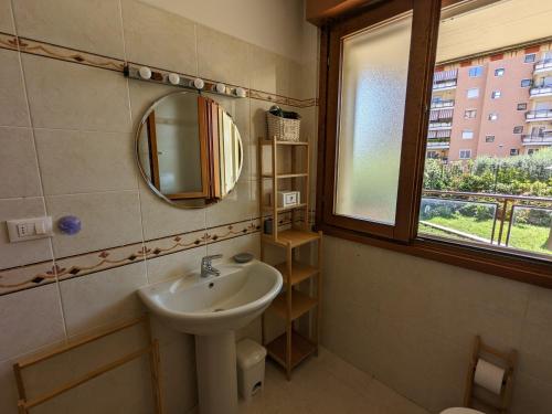 baño con lavabo, espejo y ventana en Residenza Alabama, en Roma
