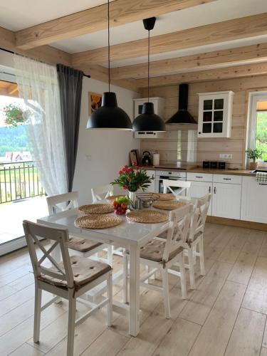 a white kitchen with a white table and chairs at ORAWSKA CHATA pod Babią Górą in Zubrzyca Górna