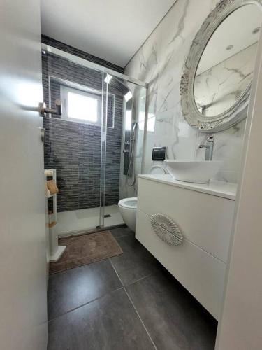 a bathroom with a sink and a toilet and a mirror at Cidade_Berço House in Guimarães