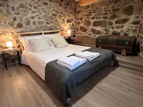 a bedroom with a bed with towels on it at Casas dos Senadores by Vale do Zêzere Hotel in Manteigas