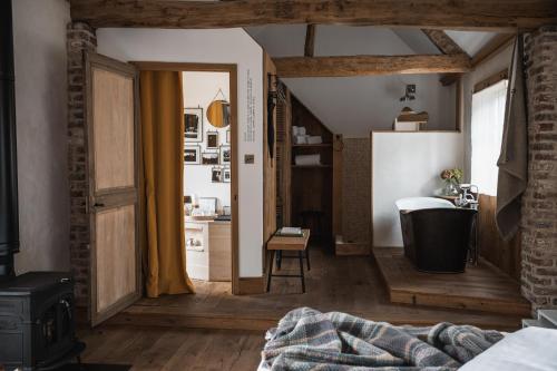 una camera da letto con bagno dotato di vasca e lavandino di La Grenouillère a Montreuil-sur-Mer