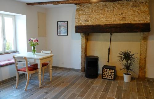 una mesa y sillas en una habitación con chimenea en Gite Rural La Maison Mauve, en Ventouse