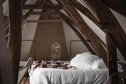 a bed with white sheets and pillows in an attic at La Grenouillère in Montreuil-sur-Mer