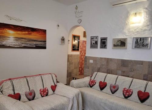 - un salon avec deux canapés avec des coeurs rouges dans l'établissement OLdBIA, à Olbia