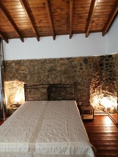 a bed in a room with a brick wall at ΑΝΑΒΑΤΟΣ ΕΞΟΧΙΚΗ ΚΑΤΟΙΚΙΑ in Chios