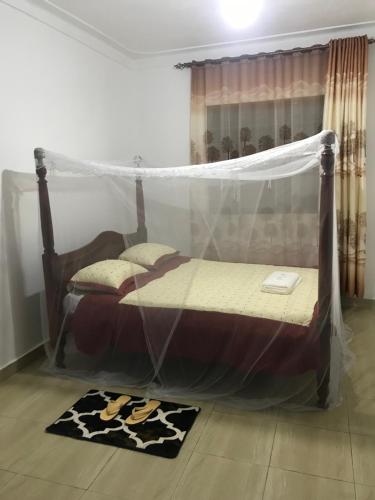 - une chambre avec un lit et une moustiquaire dans l'établissement BIMS Vacation Rental, à Fort Portal
