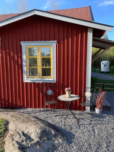 a red building with a table in front of it at Loves Bondgård in Sparreholm
