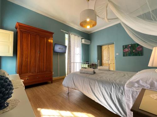 a bedroom with blue walls and a bed and a window at Mid Modern Akragas Home in Center with Sea View in Agrigento