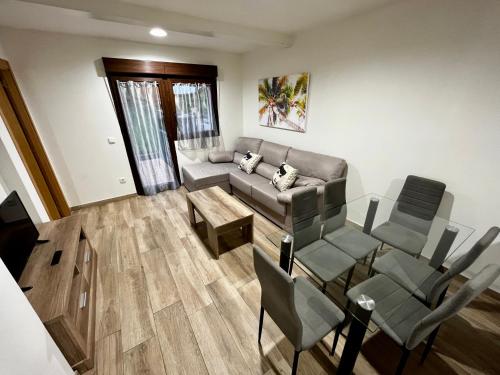 ein Wohnzimmer mit Sofa, Tisch und Stühlen in der Unterkunft Lotila Flats L'Infiestu in Infiesto