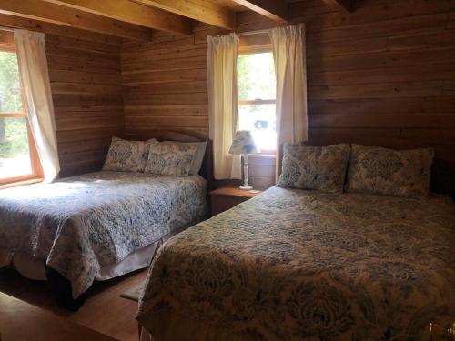 um quarto com 2 camas num chalé de madeira em Beddington Lake Log Cabin 