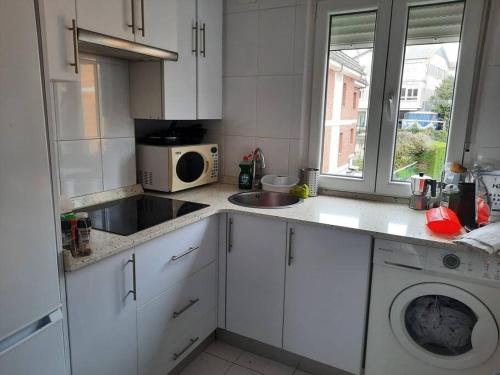 a white kitchen with a sink and a microwave at Apartamento / piso , centrico. in Santander