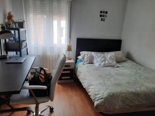 a bedroom with a bed and a desk and a chair at Apartamento / piso , centrico. in Santander