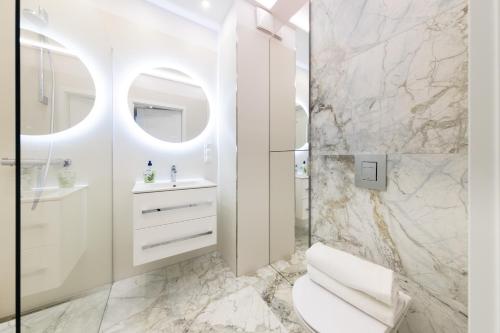 a white bathroom with a toilet and a sink at Apartament Luxury Two-bedroom in Białystok