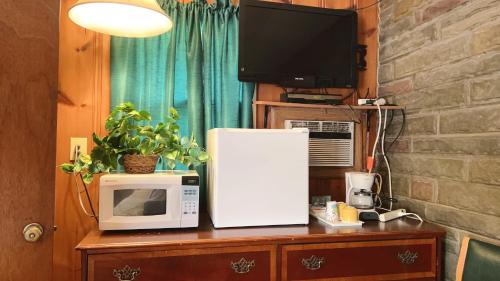 a microwave sitting on top of a wooden table at Falls Motel in Niagara Falls