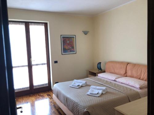 a bedroom with two beds with towels on them at Acero Rosso in Malonno