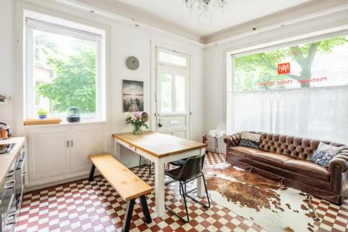 uma sala de estar com um sofá e uma mesa em Großzügige Altbauwohnung in Bestlage em Hamburgo