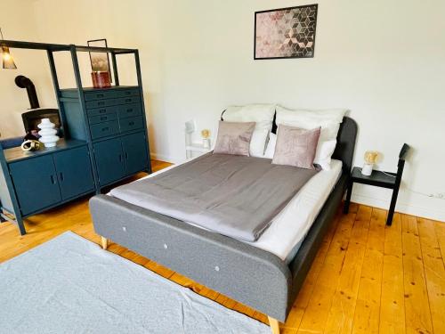 a bedroom with a bed and a blue dresser at Ferienwohnung am Ilmenauradweg 