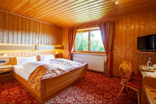 Un dormitorio con una cama grande y una ventana en Landhotel zur Grenze, en Isny im Allgäu