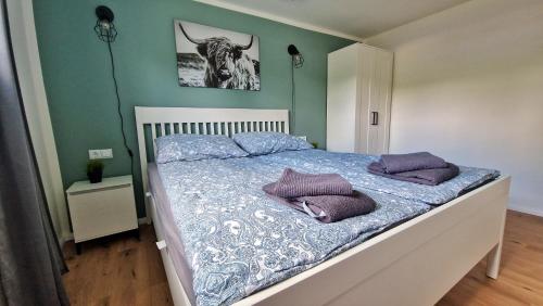 Una cama con almohadas moradas en un dormitorio en Ferienhaus Seeoase - 70qm - Kamin -Terrassen - Parkplatz - Badestelle fußläufig, en Joachimsthal