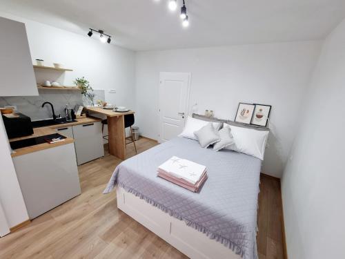 a white bedroom with a bed and a kitchen at Vila Damir in Gradac