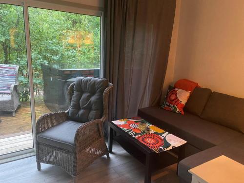 Linhagen Gård في سيفلي: غرفة معيشة مع أريكة وكرسي وطاولة